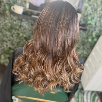Warm caramel balayage hair colour finished with soft curls